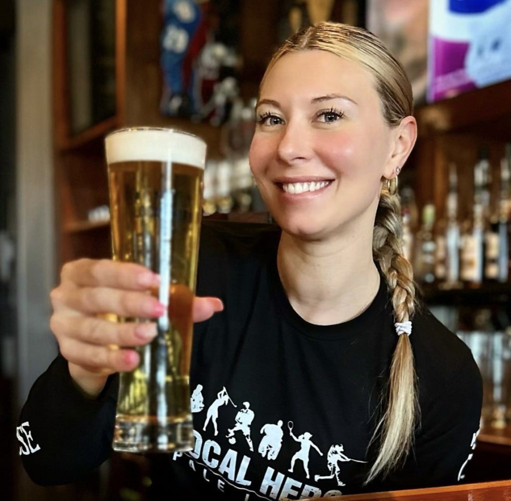 Woman holding a pint of Local Hero Pale Lager